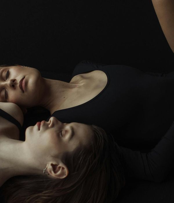 Woman in a graceful yoga pose against a dark, calm background.